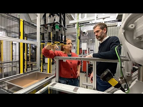 Industrieroboter greift Pakete in einem automatisierten E-Commerce-Lager – Robotik im E-Commerce