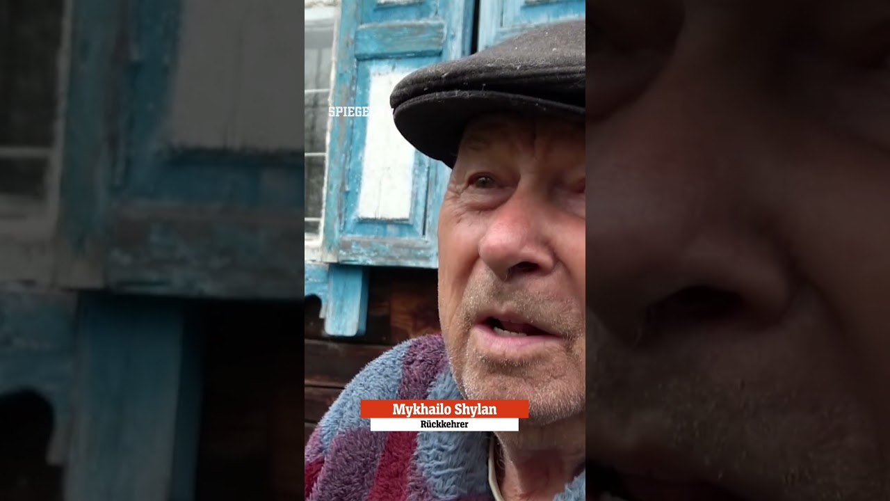 Alter Mann sitzt vor einem kleinen Haus in der Tschernobyl Sperrzone inmitten verwilderter Natur