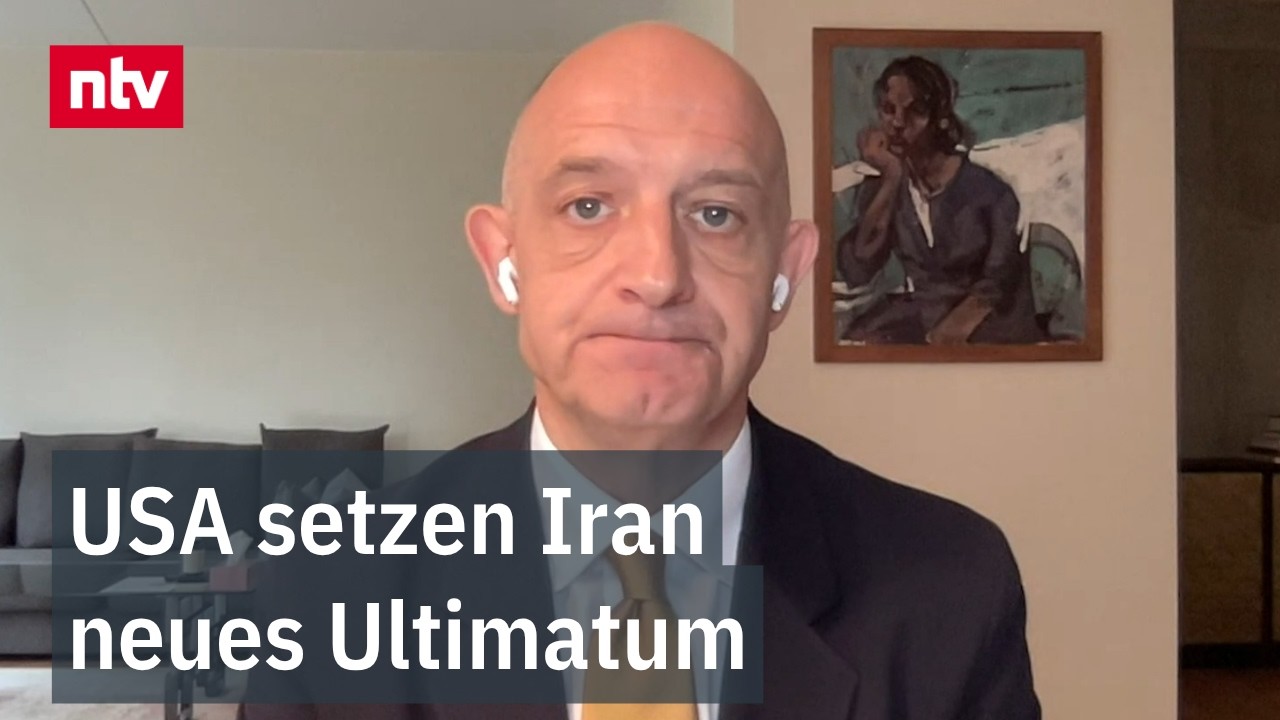 Iranische und amerikanische Flaggen vor einer Weltkarte symbolisieren den Iran-Atomstreit und diplomatische Verhandlungen