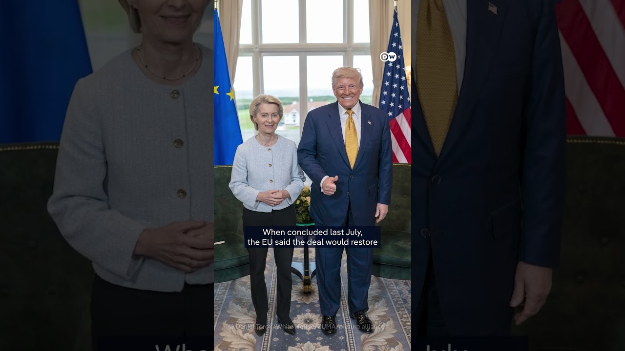 Trump Autozölle – Donald Trump spricht über Autozölle auf EU-Fahrzeuge, im Hintergrund Flaggen der USA und der EU