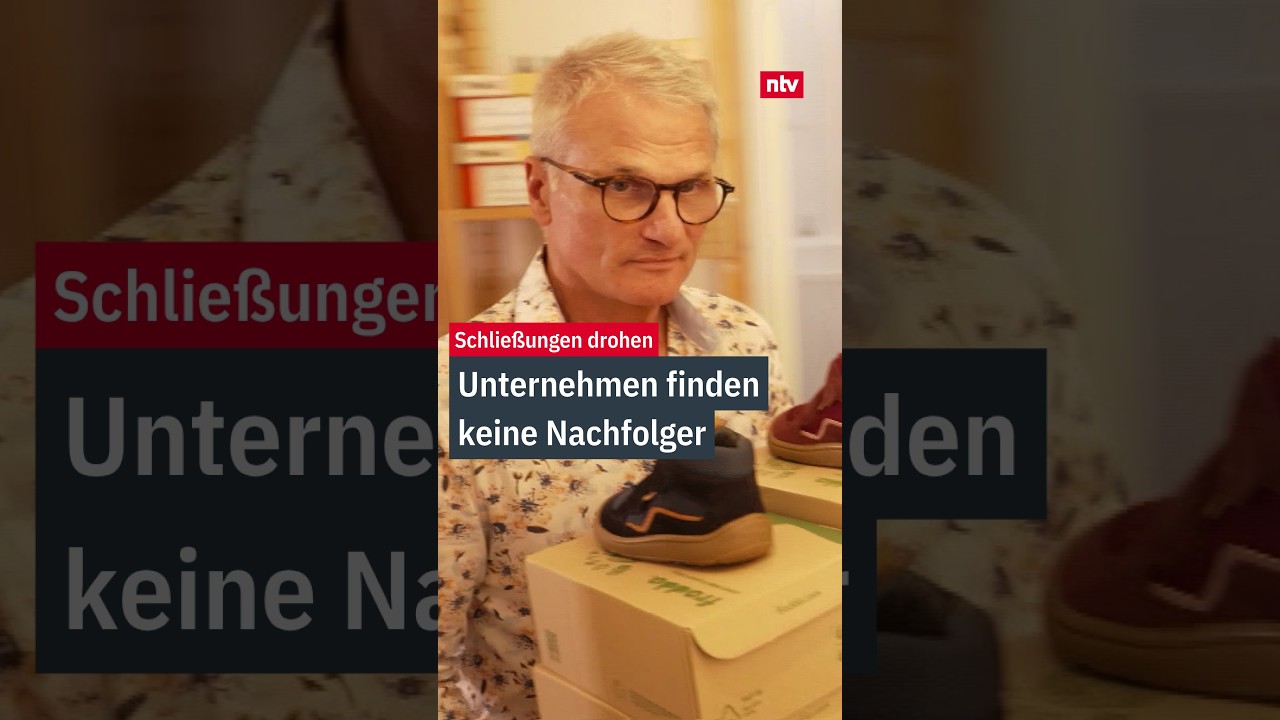 Inhaber eines kleinen Fachgeschäfts übergibt symbolisch einen Schlüssel – Unternehmensnachfolge im Mittelstand