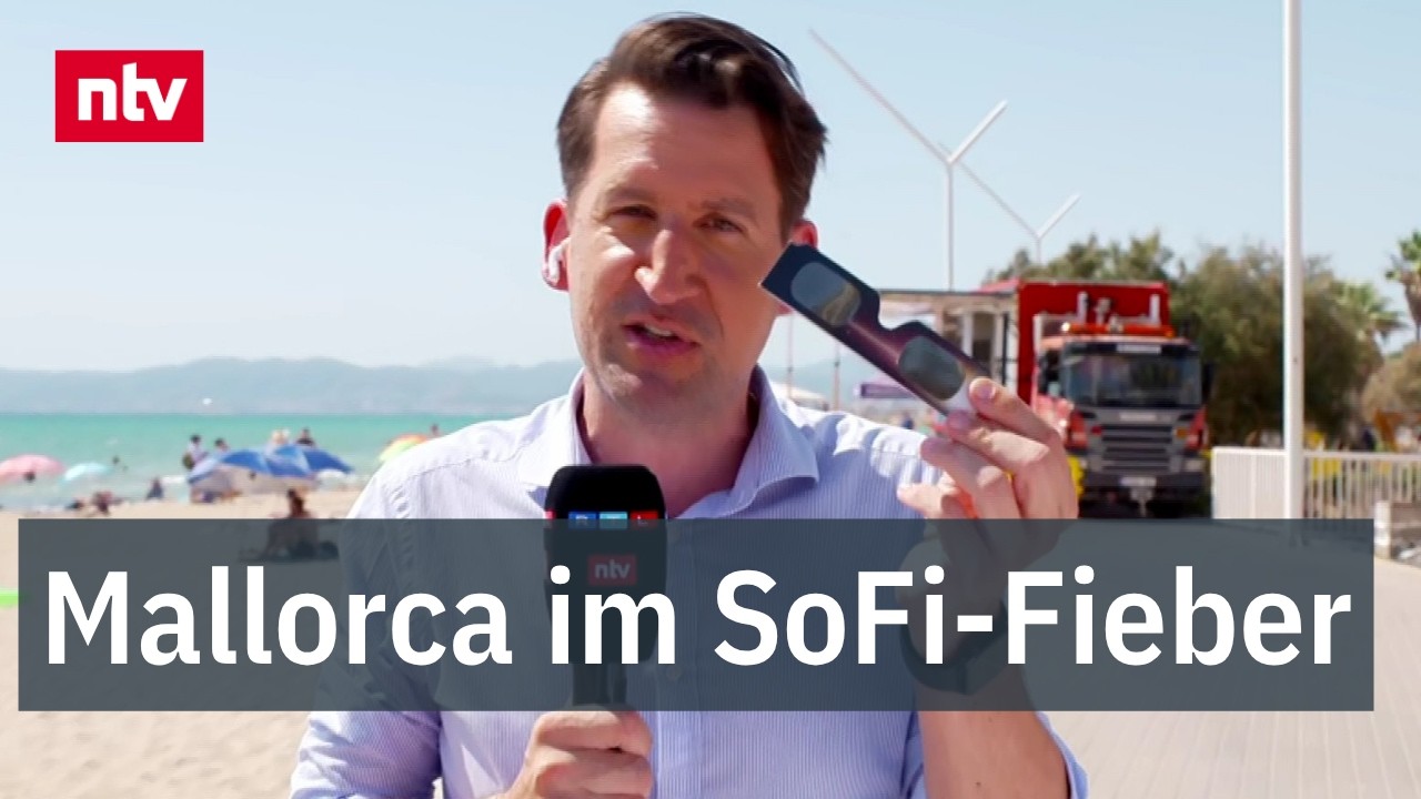 Sonnenfinsternis Mallorca – Menschenmenge an der Playa de Palma beobachtet die totale Sonnenfinsternis auf Mallorca mit Schu…