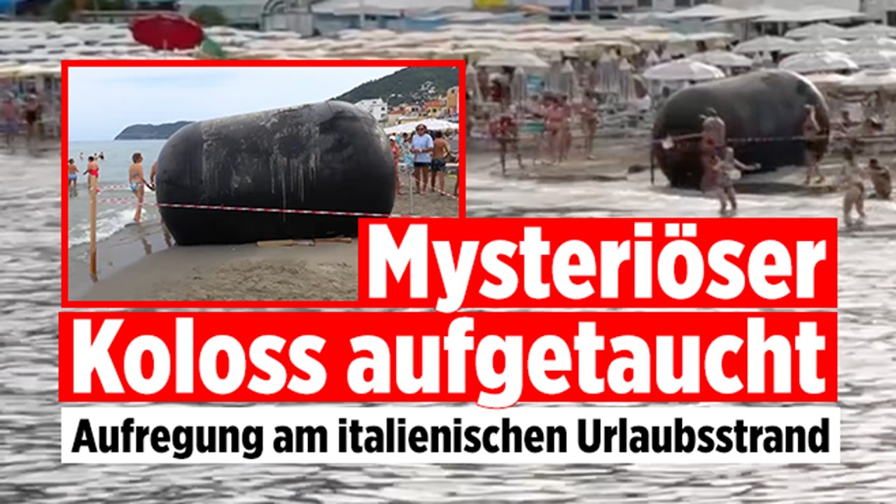 Fender Strand Alassio – Riesiger zylindrischer Schiffsfender liegt am Badestrand von Alassio in Italien zwischen Strandbesuc…