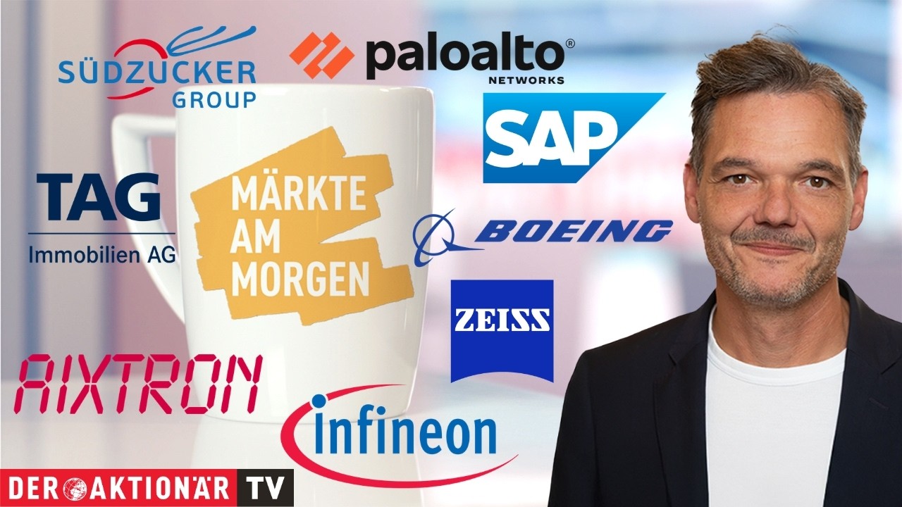 Börsenhändler verfolgt Märkte am Morgen auf mehreren Bildschirmen mit DAX- und Aktienkursen
