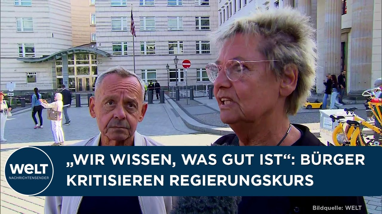 Bundeskanzler Friedrich Merz bei einer Pressekonferenz, umgeben von Mikrofonen und kritischen Blicken