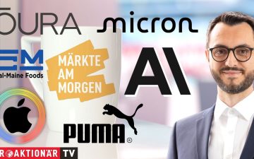 Händler an der Börse verfolgen die Märkte am Morgen auf digitalen Kursanzeigen mit Apple- und Micron-Aktien