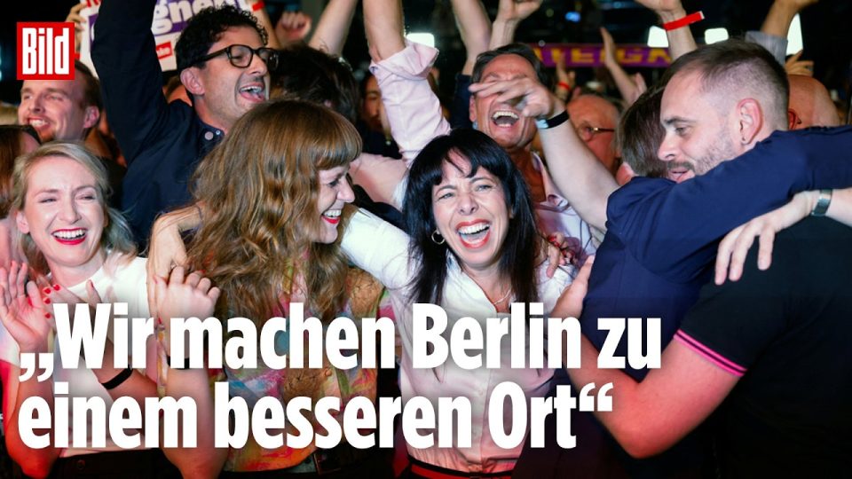 Jubelnde Unterstützer der Linken bei der Berliner Wahl 2026, Spitzenkandidatin hält Siegesrede auf der Bühne