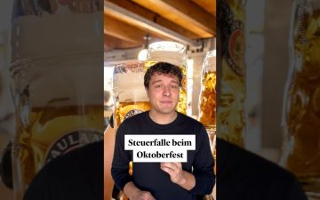 Mitarbeitende stoßen mit Maßkrügen auf dem Oktoberfest an – Steuerfalle Oktoberfest bei Firmenfeiern