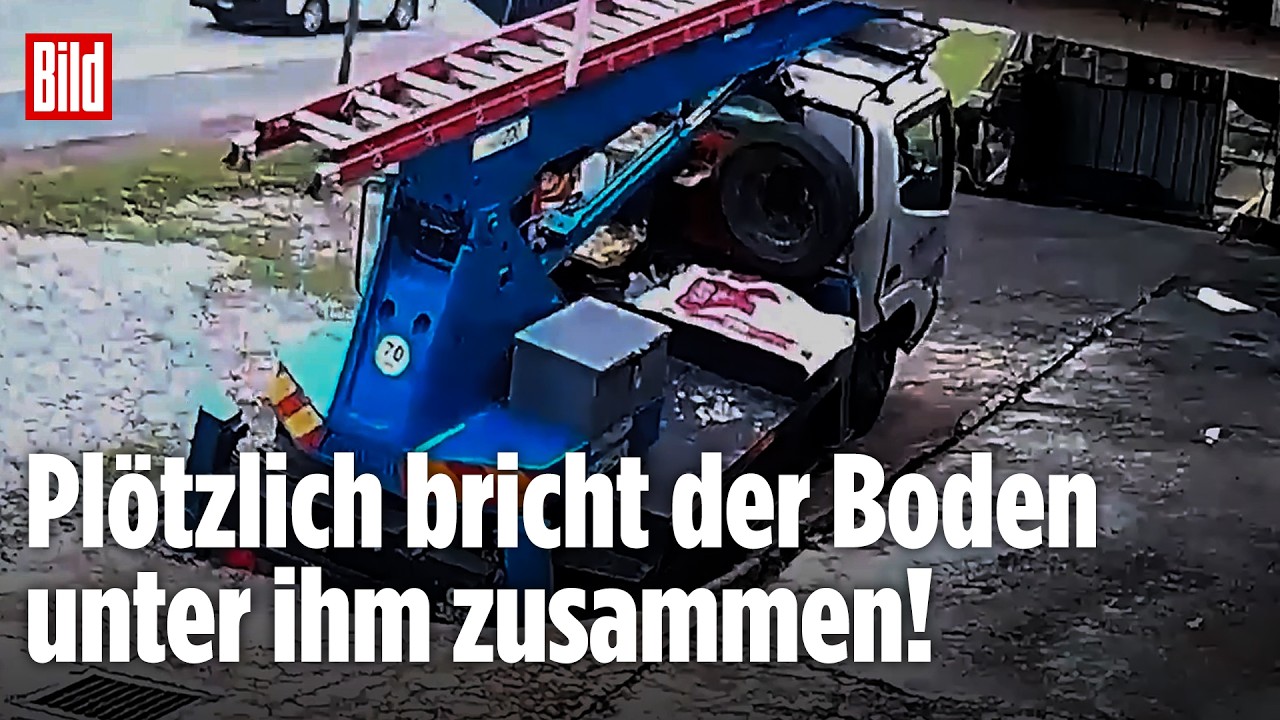 Kranwagen versinkt halb in eingebrochenem Asphalt über einem Abwasserkanal – Asphalt bricht ein