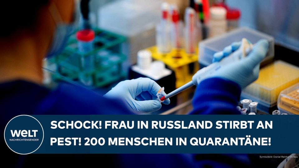 Laborantin in Schutzausrüstung hält Reagenzglas – Symbol für Pest-Laborunfall in Irkutsk, Russland