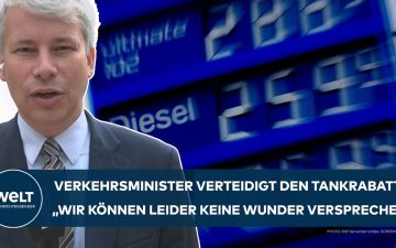 Bundesverkehrsminister Steffen Bilger (CDU) verteidigt den Tankrabatt vor Mikrofonen – Zapfsäulen im Hintergrund
