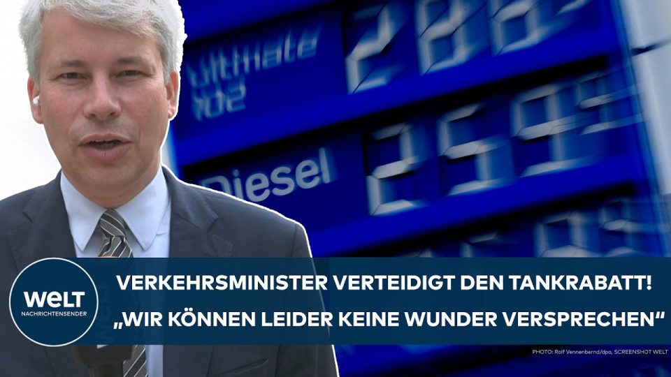 Bundesverkehrsminister Steffen Bilger (CDU) verteidigt den Tankrabatt vor Mikrofonen – Zapfsäulen im Hintergrund