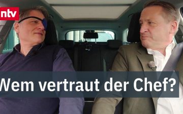 Mitarbeiterin arbeitet im Homeoffice am Laptop, während Kollegen im Büro sitzen – Debatte um Homeoffice Präsenzpflicht