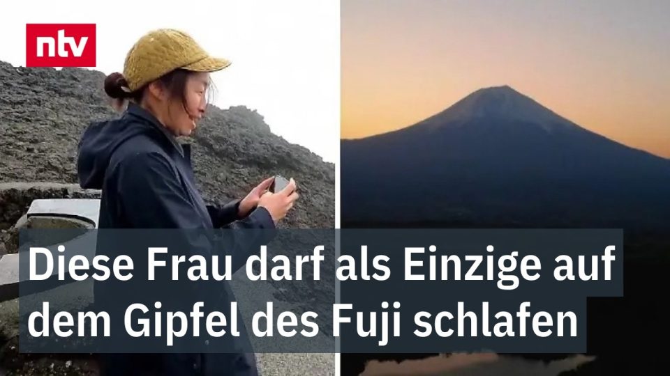 Fuji-Fotografin Megumi Ueda steht im Nebel auf dem Gipfel des Mount Fuji mit Kamera in der Hand