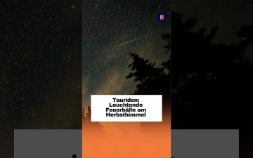 Leuchtender Feuerball der Tauriden am nächtlichen Herbsthimmel über einer dunklen Landschaft